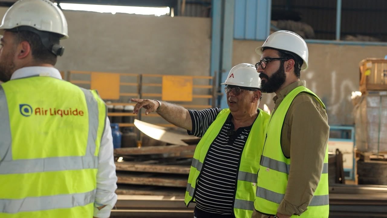 Eslam in a hard hat and safety vest during an Air Liquide site visit