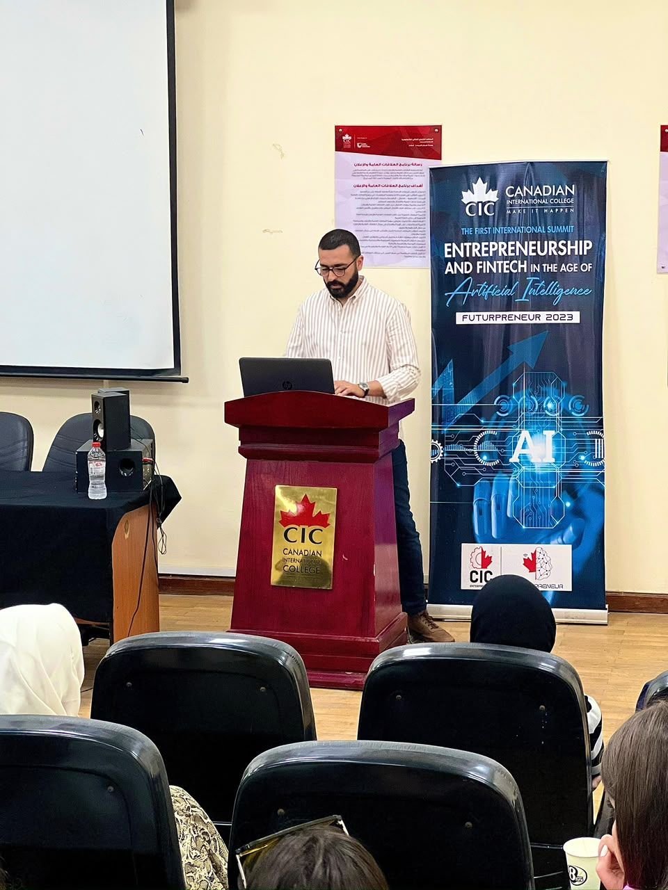 Eslam Toba speaking at a podium at Canadian International College