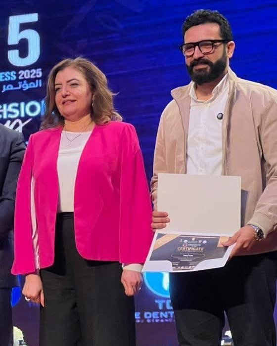 Eslam Toba holding a certificate on stage at the IDC25 conference