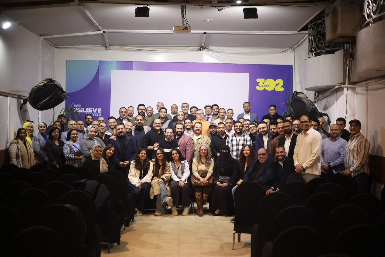Large group photo of attendees in a venue with Eslam Toba