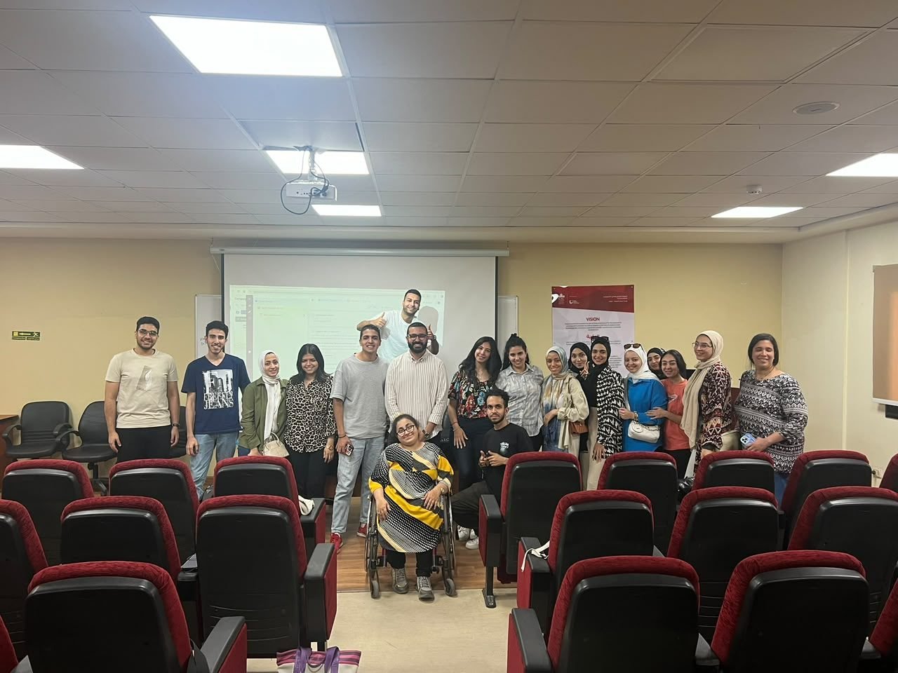 Eslam Toba with a group of students in a lecture hall after a session
