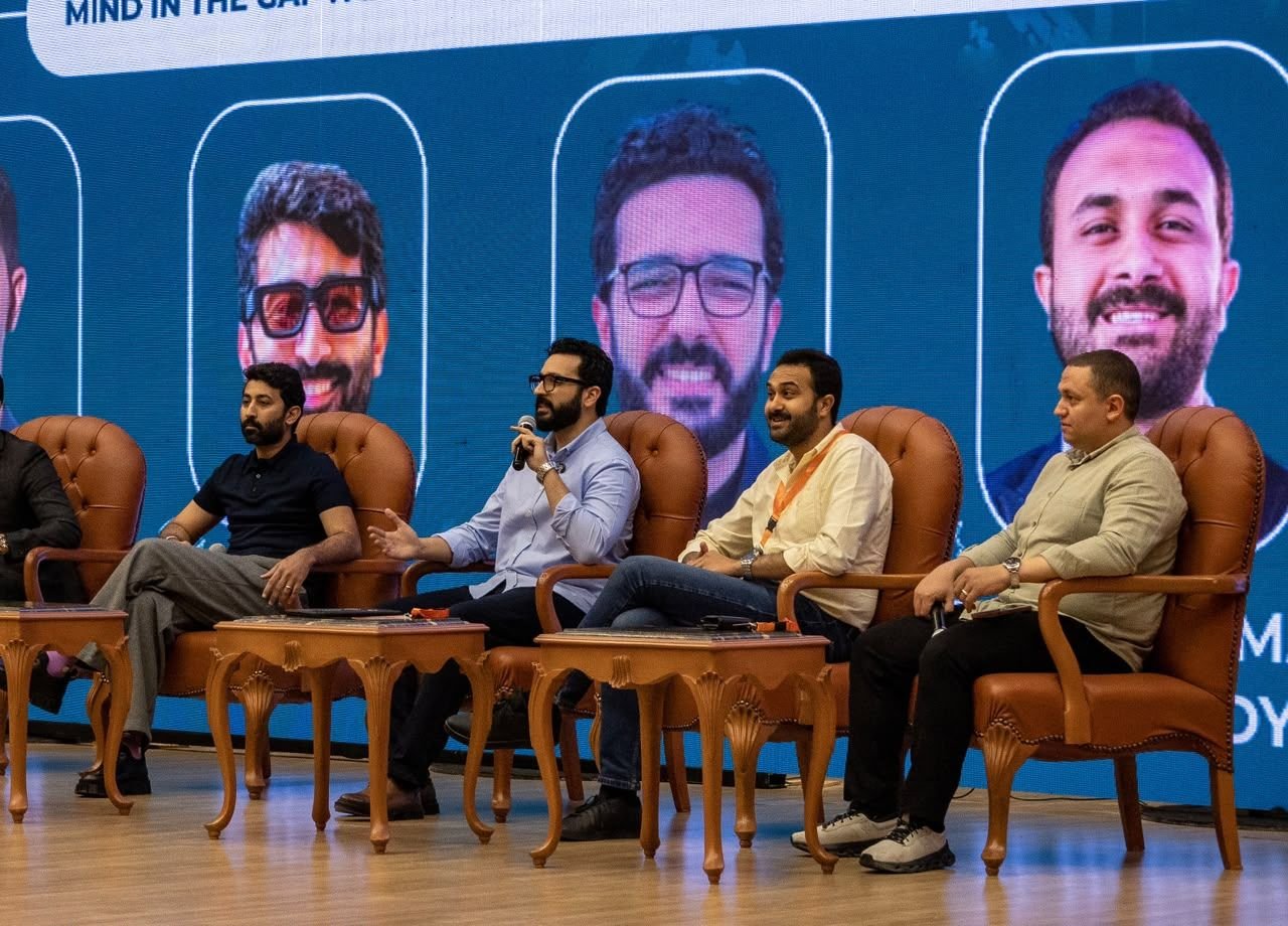 Eslam Toba speaking on a four-person panel on stage