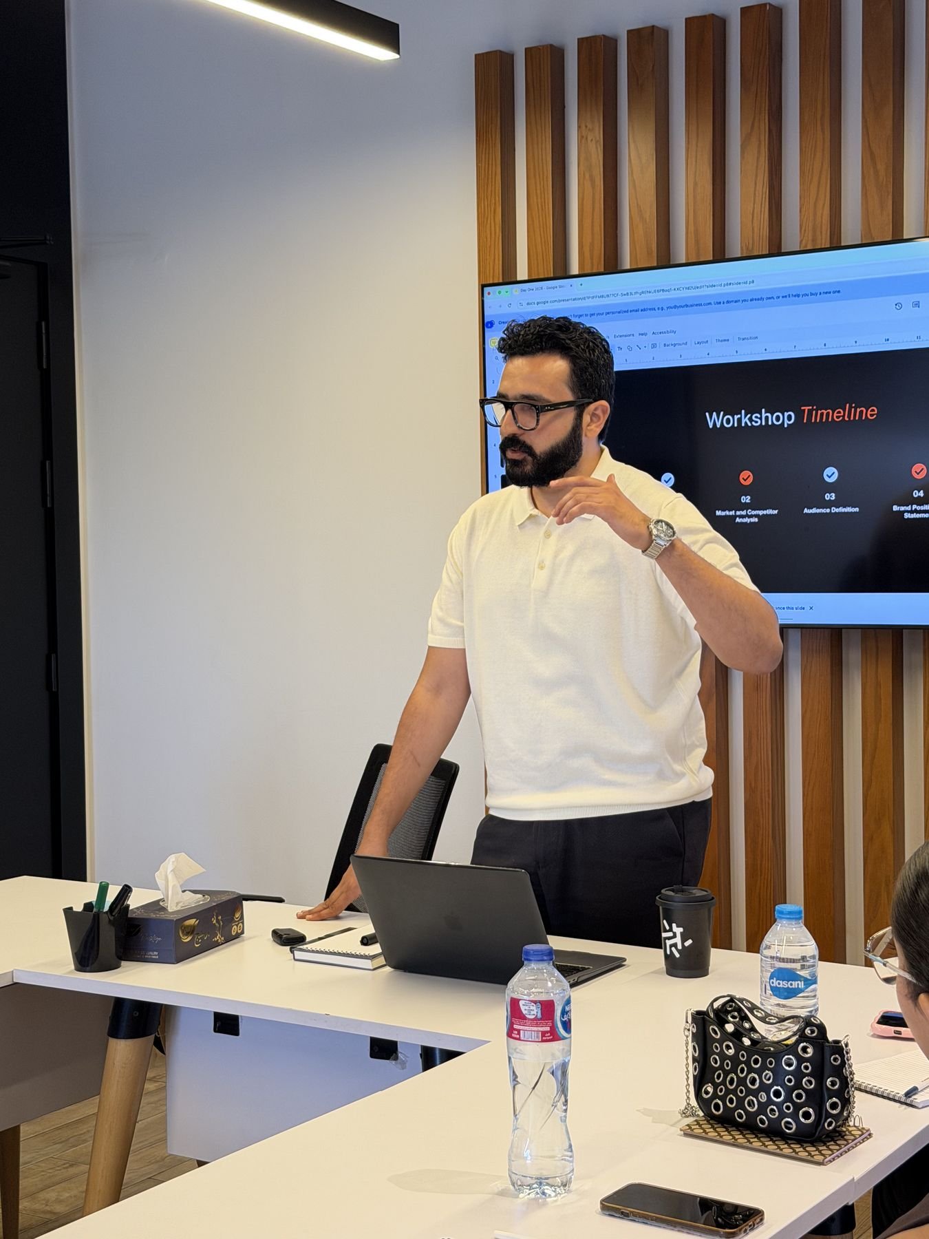 Eslam Toba leading a workshop beside a presentation screen